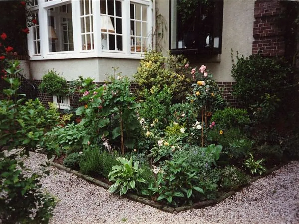 Blühendes Staudenbeet vor weißem Sprossenfenster – Kontakt zu Harje Garbade Garten